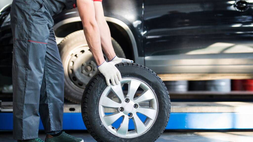 Obrazek przedstawia mechanika, który turla koło