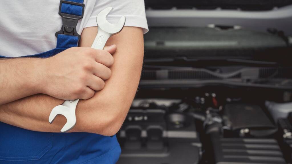 Obrazek przedstawia mechanika samochodowego