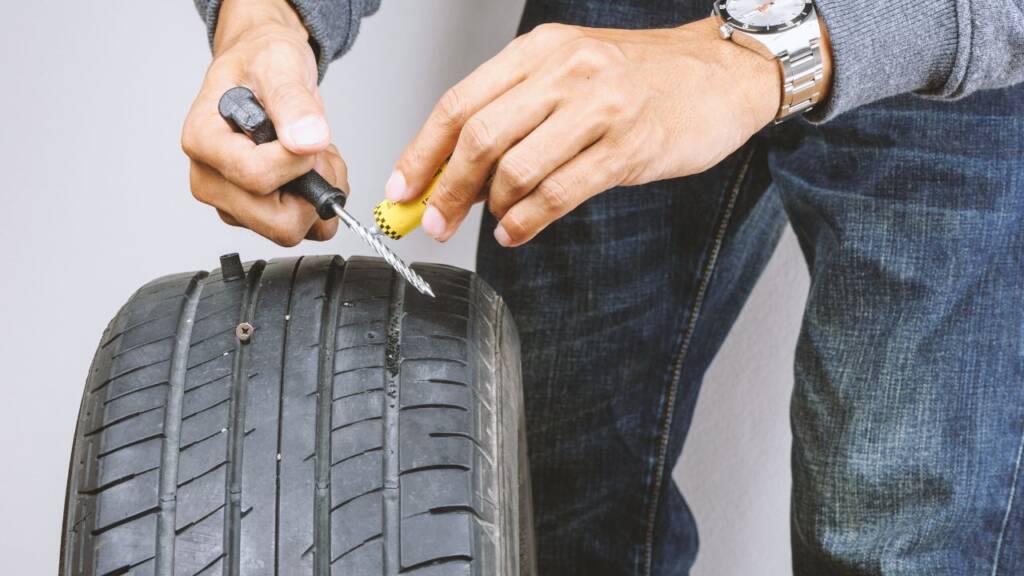 Ręczne naprawianie przebitej opony przy pomocy zestawu naprawczego